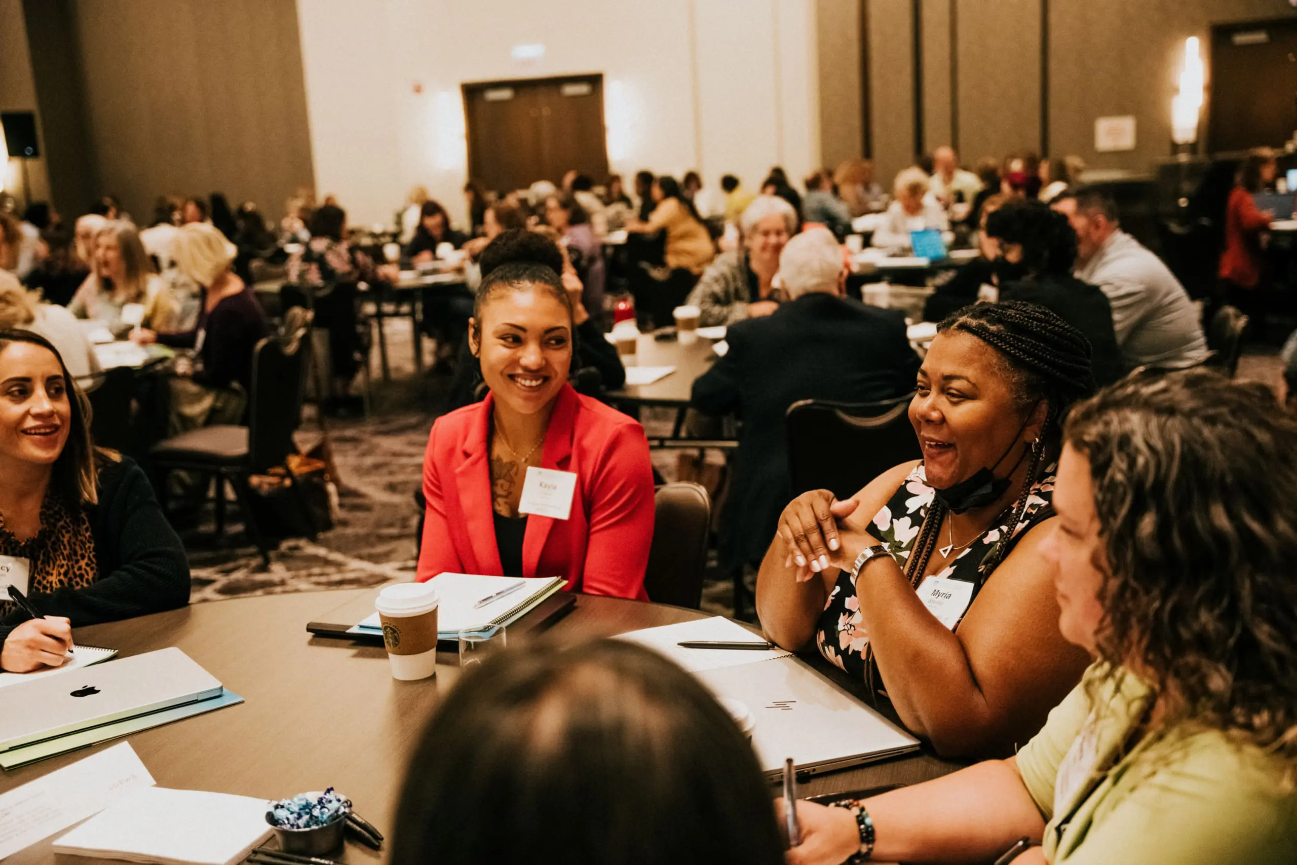 group of women sitting at table smiling and discussing