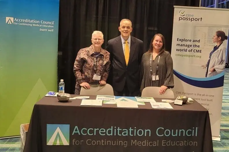 three people standing in front of table